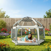 Children playing inside a dome-shaped playpen with colorful toys hanging above.