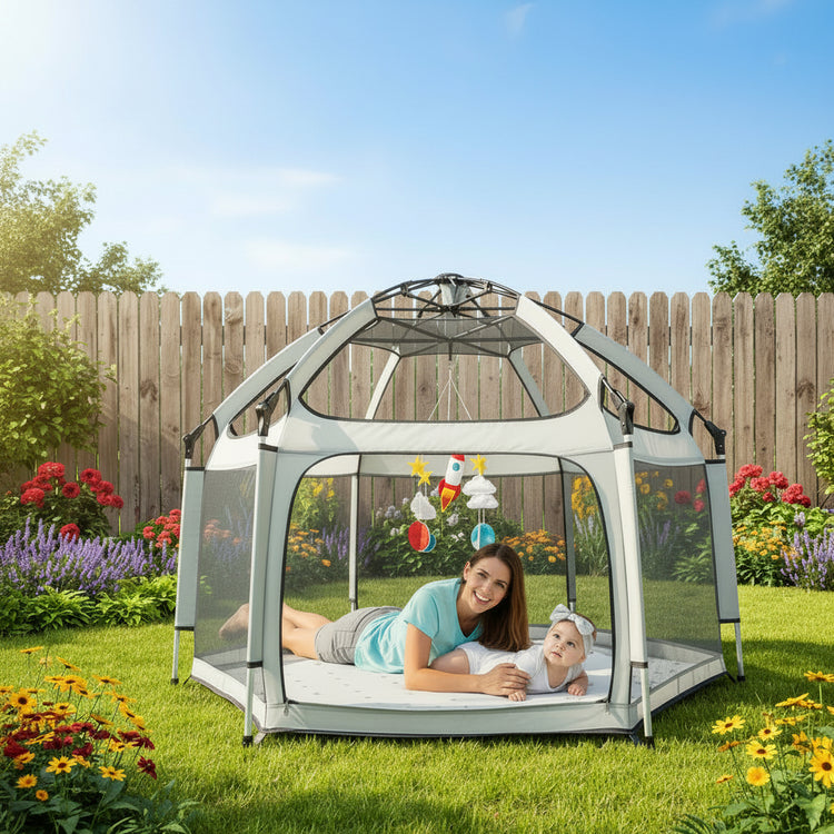 Children playing inside a dome-shaped playpen with colorful toys hanging above.